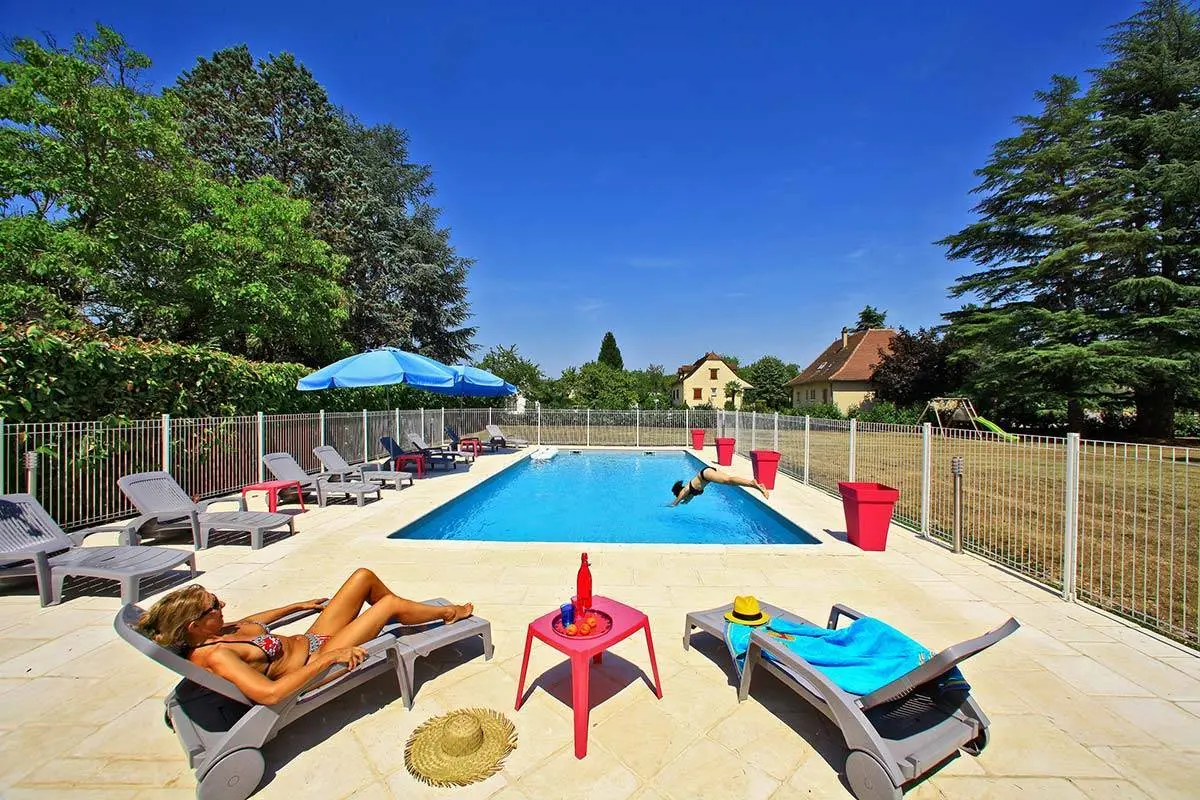 Piscine avec transats et personnes profitant de la baignade en été