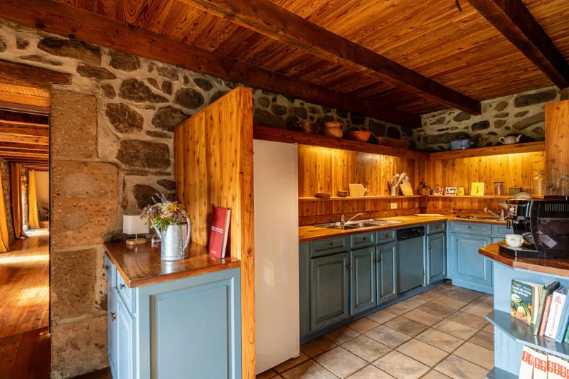 Cuisine équipée aux tons bleus avec plan de travail en bois et carrelage