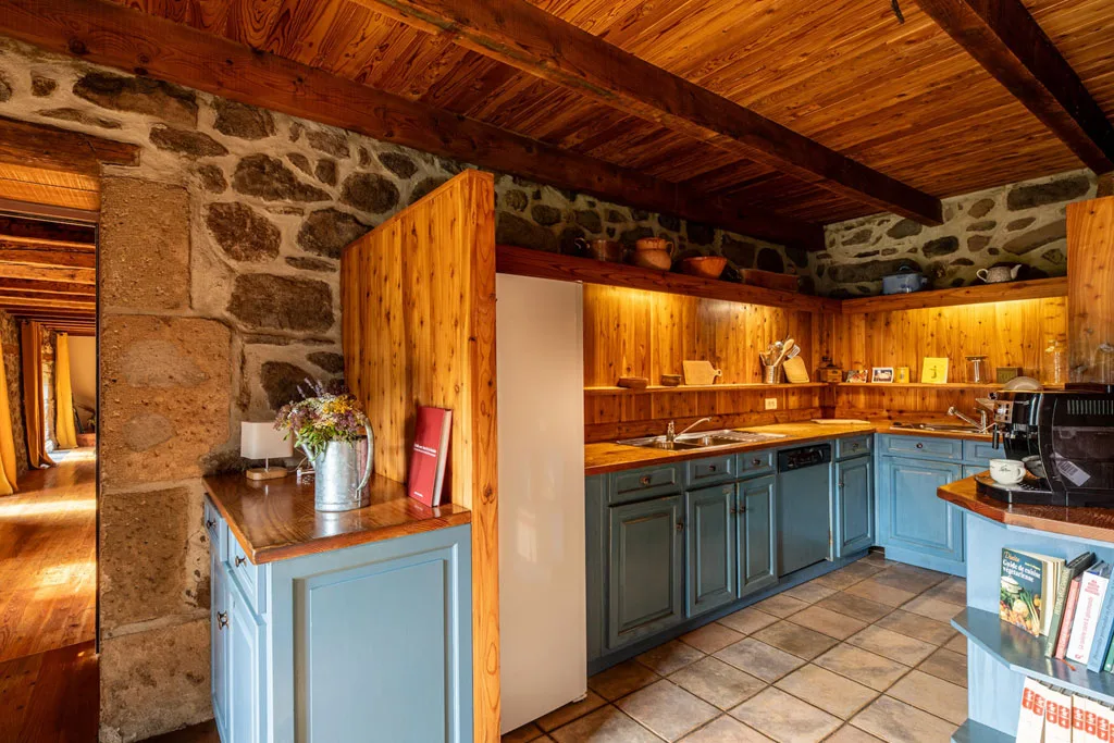 Cuisine équipée aux tons bleus avec plan de travail en bois et carrelage