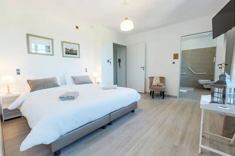 Chambre accessible PMR avec salle de douche à l'italienne et barres d'appui