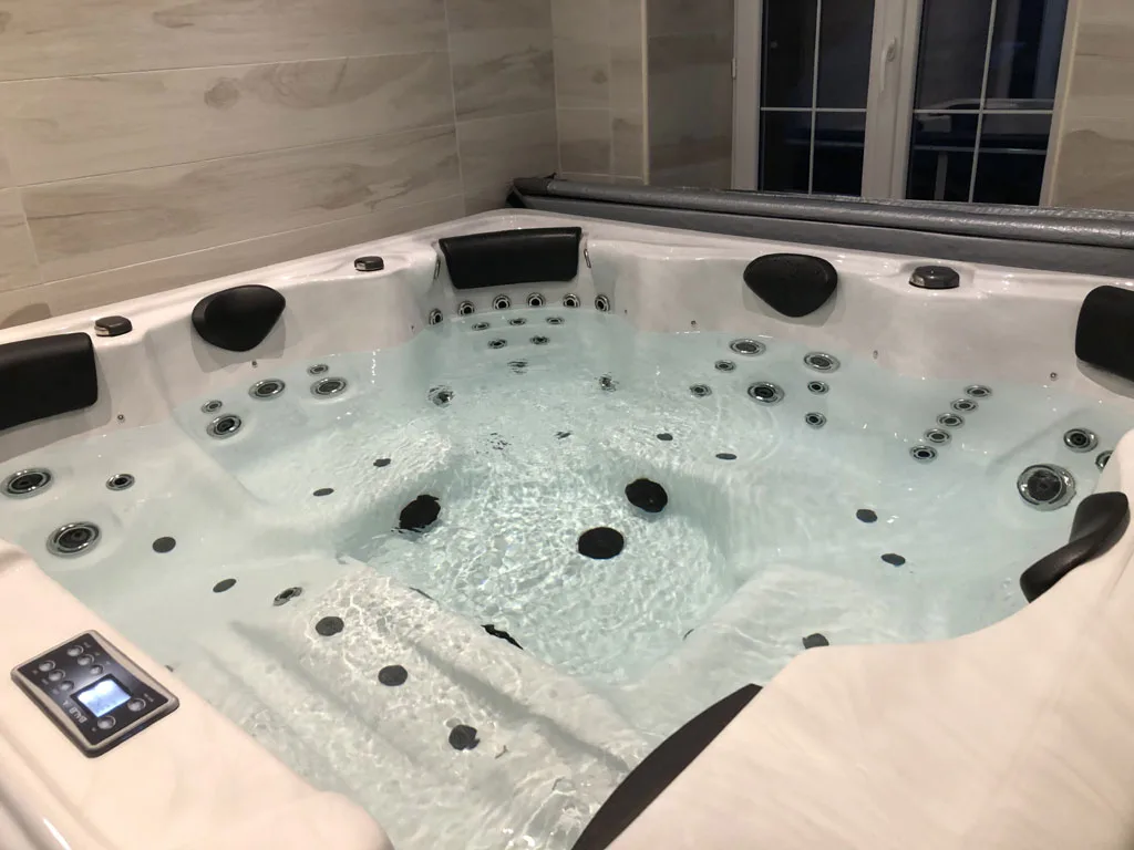 Spa jacuzzi et hammam intérieur avec jets et vue sur la terrasse