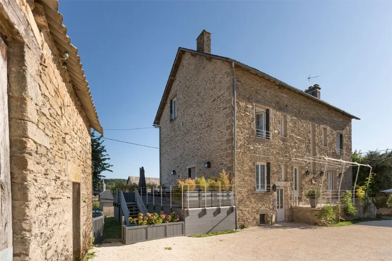 Façade en pierre du domaine, ancienne auberge de village avec toiture d'ardoise