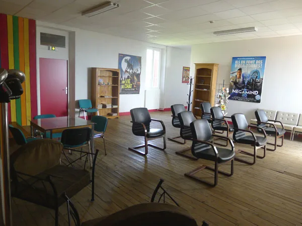 Salle commune avec bibliothèque, affiches de cinéma et chaises en arc de cercle