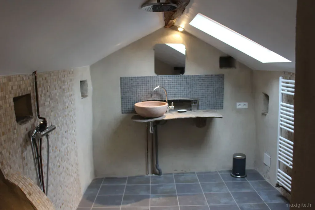 Salle de bain mansardée avec vasque en pierre ronde et faïence mosaïque bleu-gris