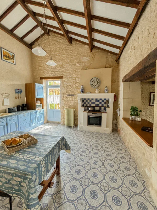 Cuisine en pierre apparente avec carrelage à motifs bleus et cheminée décorative