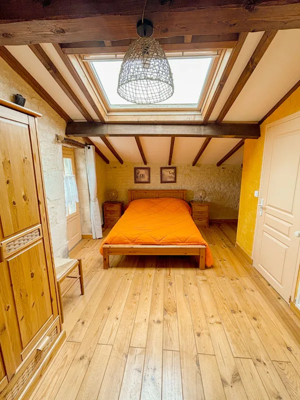 Façade en pierre du gîte avec terrasse dressée pour le déjeuner sous tonnelle
