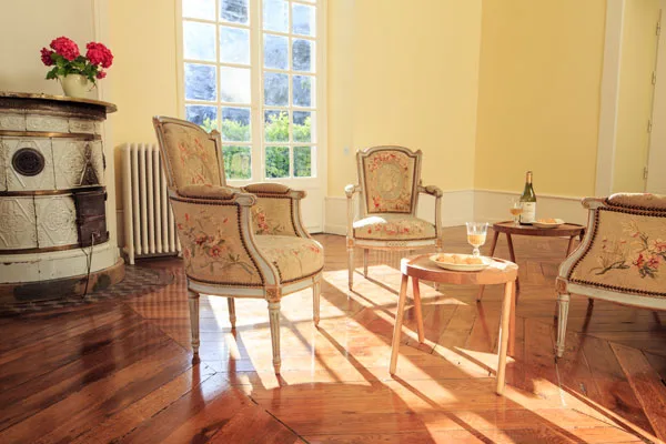 Salon lumineux avec poêle en faïence ancien et moulures