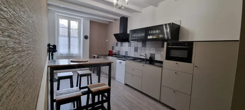 Deuxième cuisine équipée avec bar et hotte noire suspendue