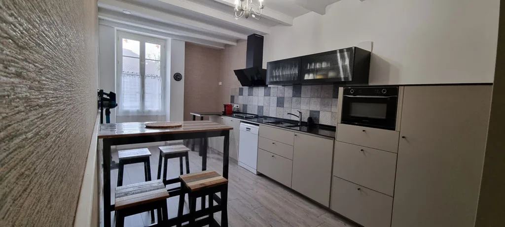 Deuxième cuisine équipée avec bar et hotte noire suspendue