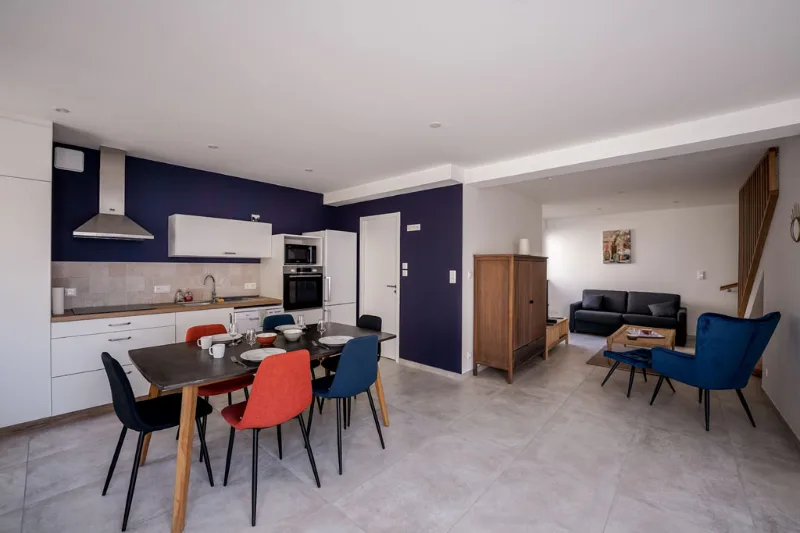 Séjour lumineux et moderne avec fauteuils bleus et grande baie vitrée
