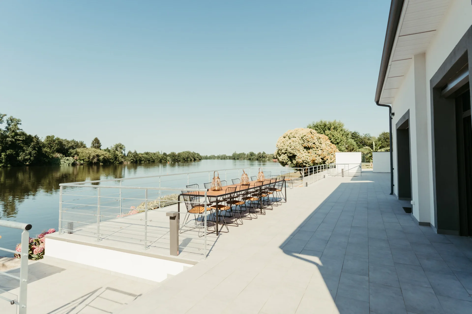 Terrasse au bord du Lot avec grande table dressée pour un repas de groupe