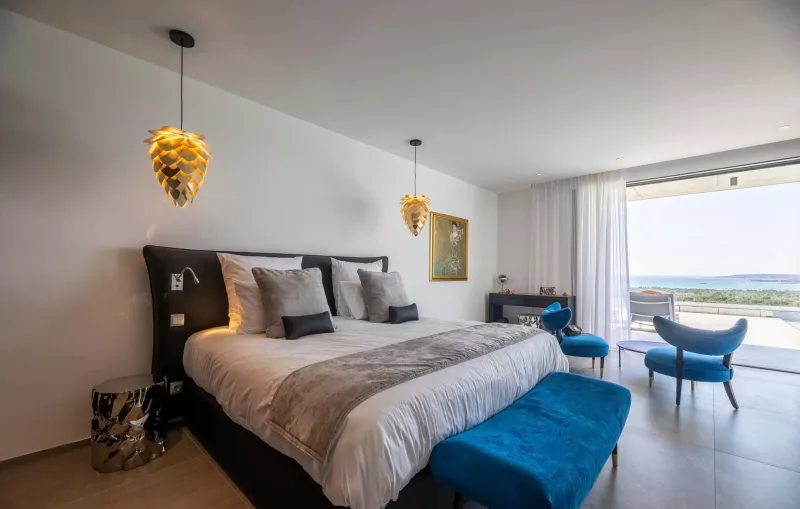 Chambre avec lit double, tête de lit noire et vue sur la mer
