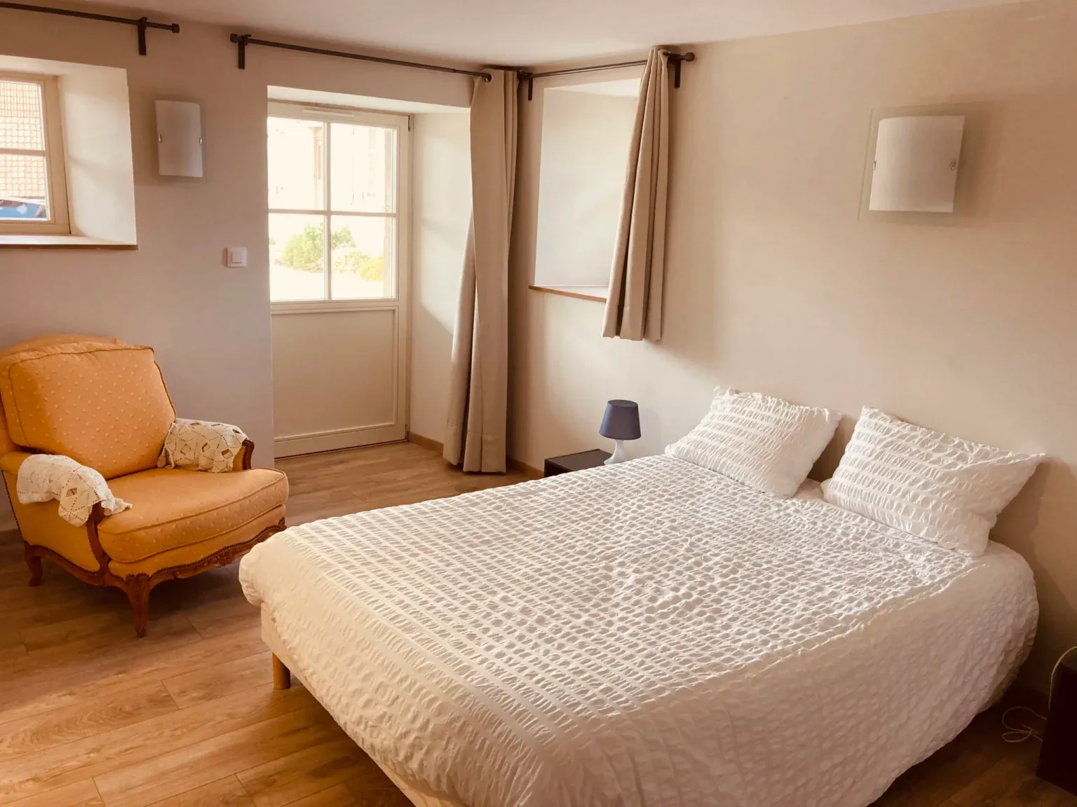 Chambre à deux lits jumeaux avec linge de lit à motifs et étagères en bois rouge