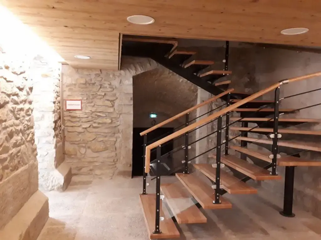 Escalier design menant à la cave voûtée en pierre du bâtiment