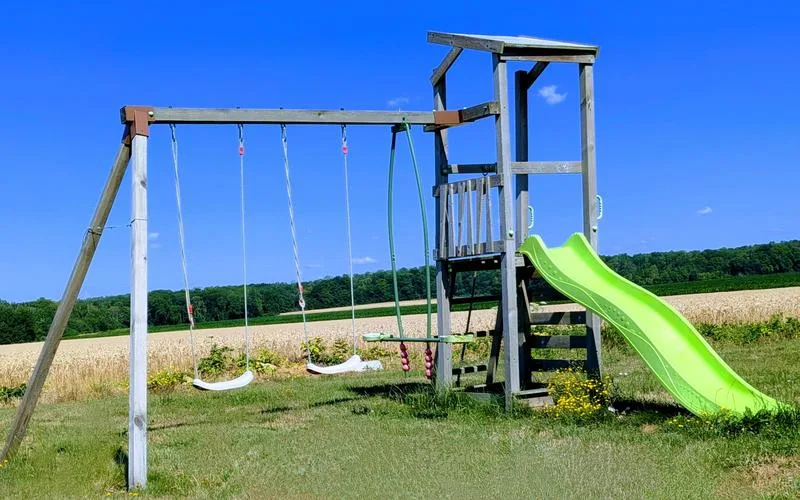 Aire de jeux extérieure avec balançoires et toboggan pour les enfants