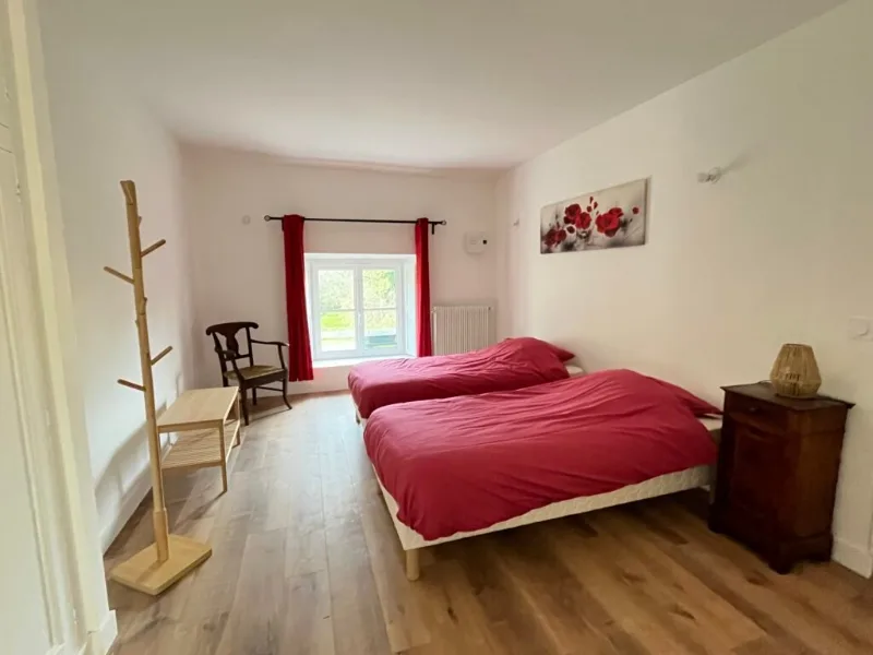 Chambre aux tons rouges avec deux lits simples