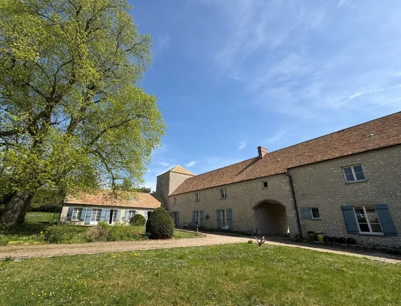 Façade en pierre du Logis Soandre entourée d'un grand arbre