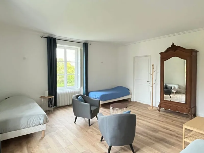 Chambre avec lits simples bleu et blanc et armoire ancienne