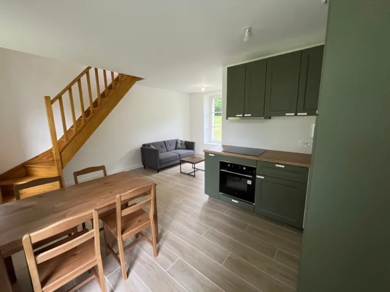 Cuisine ouverte vert sauge avec coin repas et escalier en bois