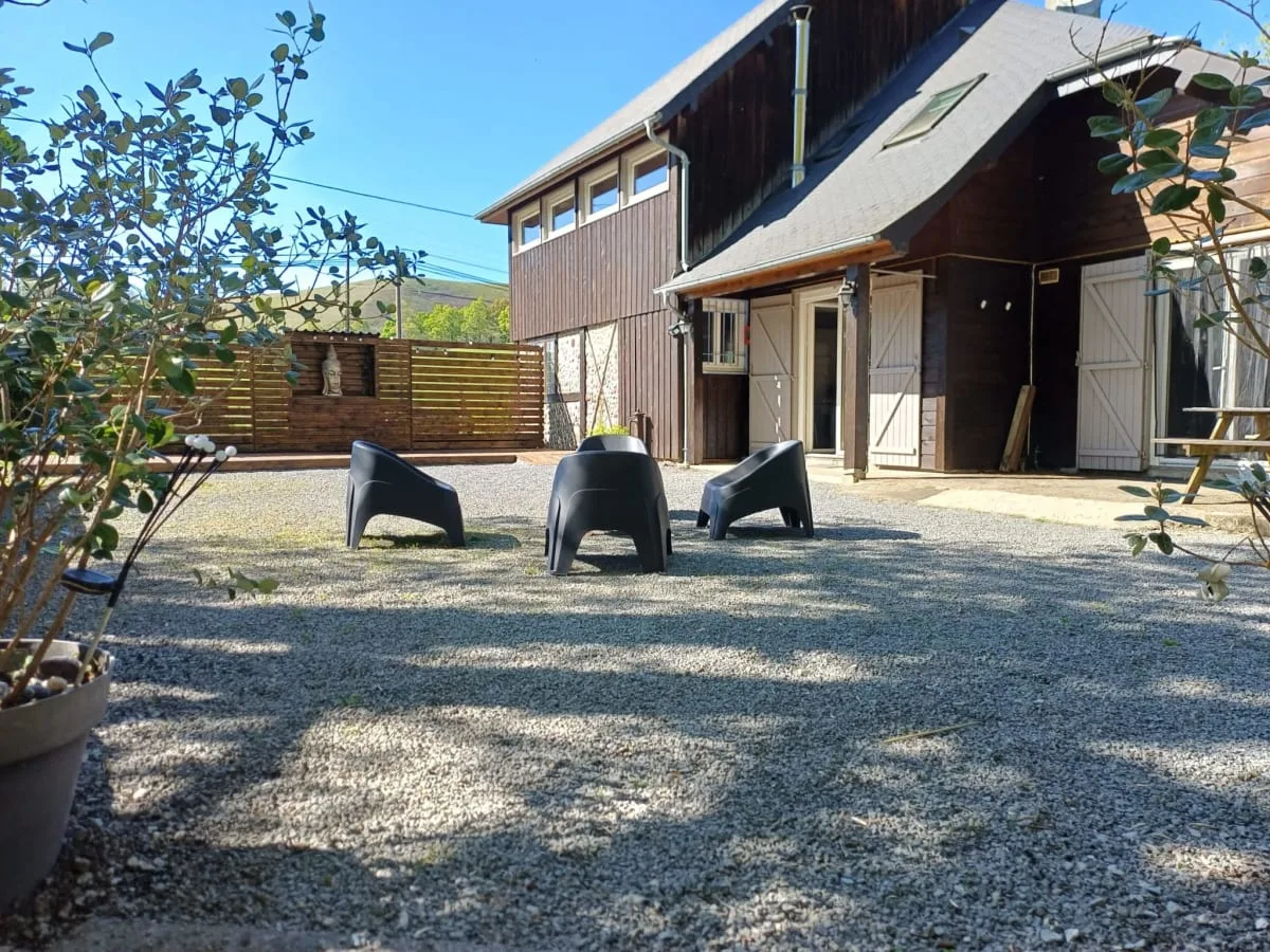 Gîte de groupe Gîte des Mousquetaires à Aramits — Gîte des Mousquetaires à Aramits vu de face, grande bâtisse en bois et pierre avec véranda et jardin arboré, capacité 15 personnes