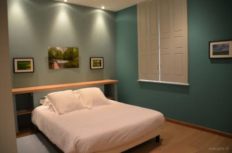 Chambre double aux tons verts avec tableaux et vue sur la campagne