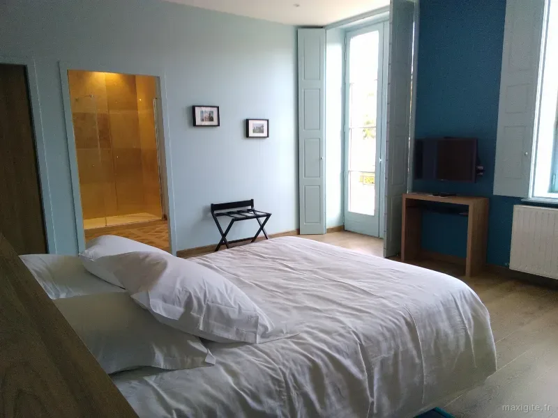 Chambre double aux tons bleus avec salle d'eau attenante et accès balcon