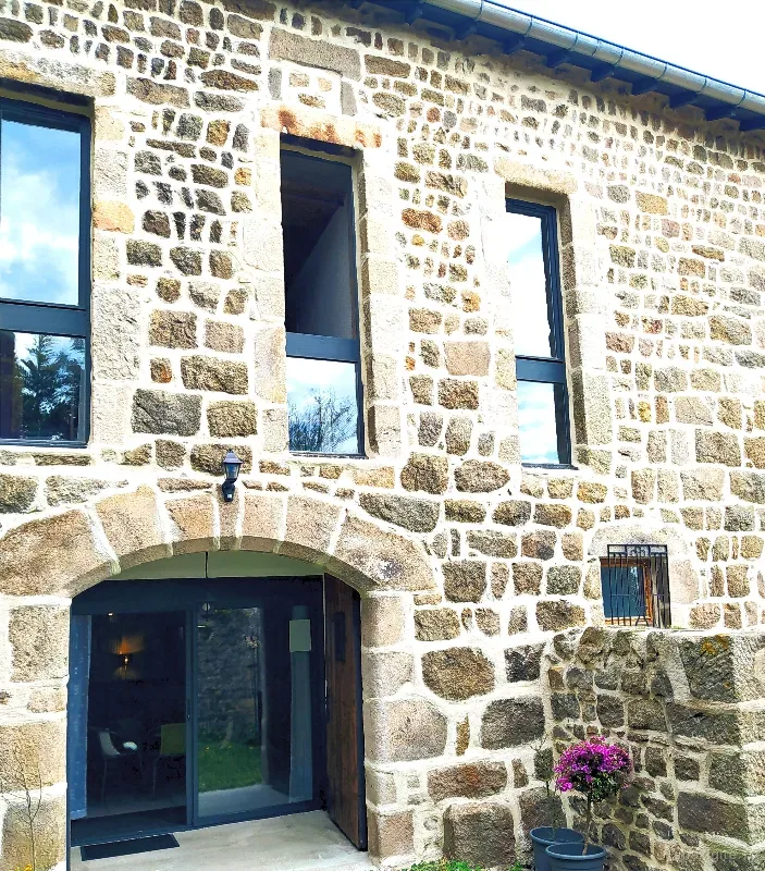 Façade en pierre de la Bâtisse aux Lanternes, entrée voûtée et fenêtres en pierre de taille