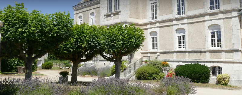 Façade du château vue depuis le jardin planté de lavande et d'arbres