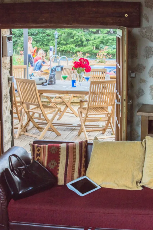 Salon avec canapé et vue sur la terrasse extérieure, gîte de la Jéraphie