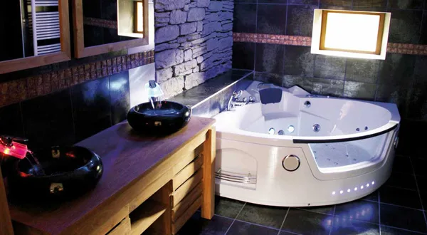 Salle de bain avec baignoire balnéo d'angle, gîte de la Jéraphie