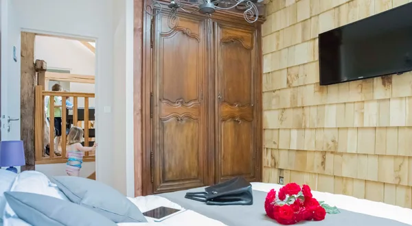 Chambre avec armoire ancienne en bois et télévision, gîte de la Jéraphie