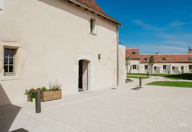 Façade en pierre et cour intérieure du Chêne Vert, ancien corps de ferme rénové à Lureuil