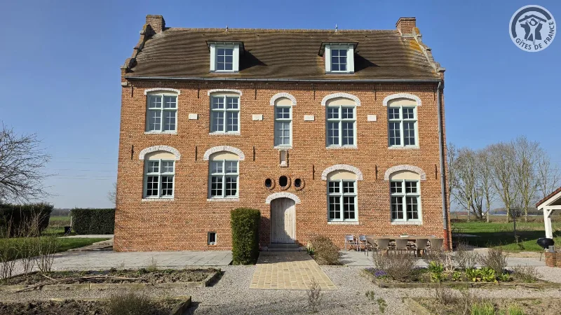 Façade en briques du Manoir du Bolgaro avec terrasse et table dressée en extérieur