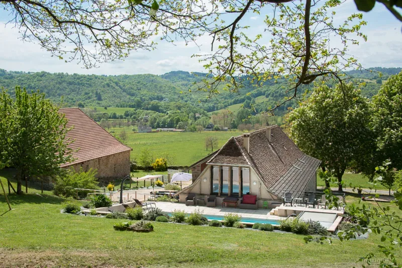 Vue d'ensemble du gîte et de la piscine dominant la vallée