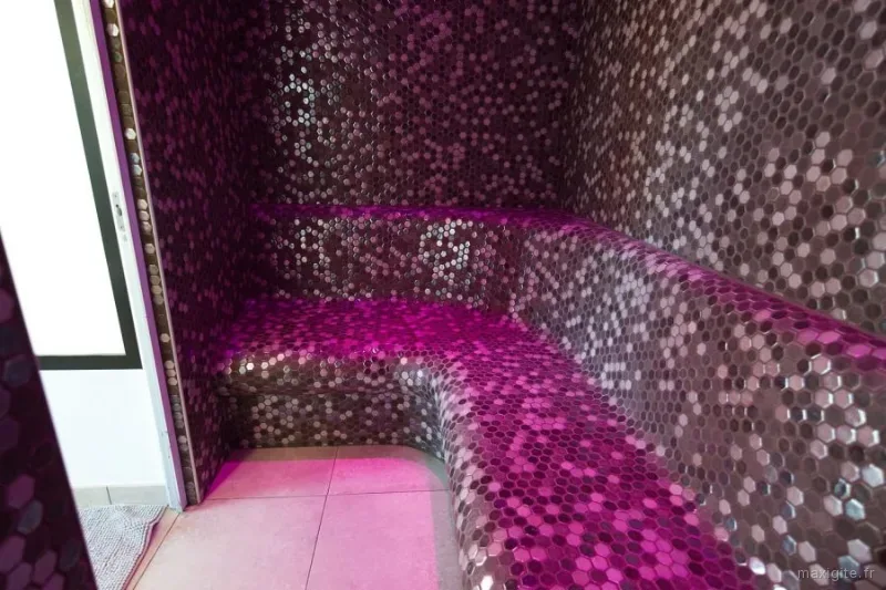 Hammam privatif en mosaïque violette avec éclairage d'ambiance et banquette