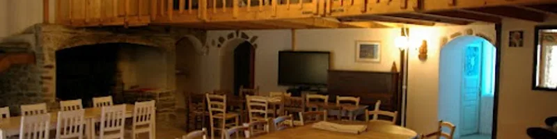 Salle à manger avec cheminée en pierre et grande table conviviale pour les groupes