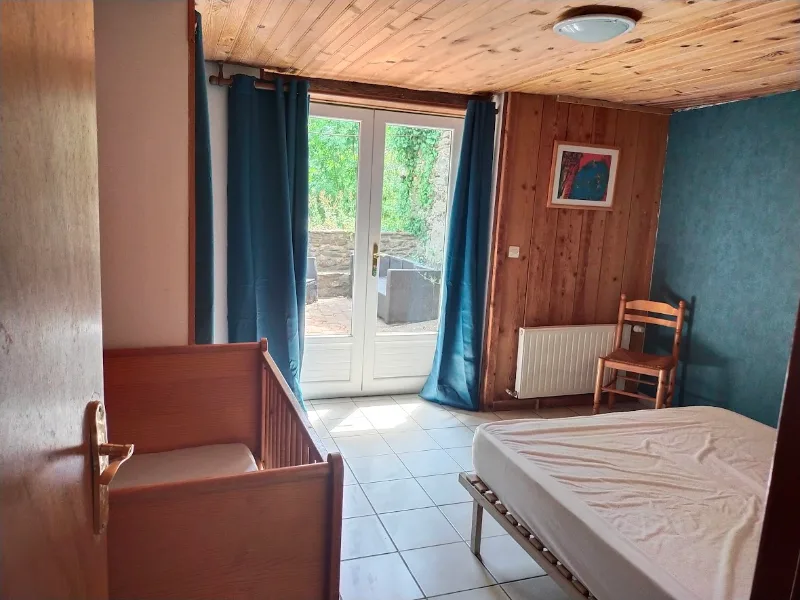 Chambre avec deux lits et vue dégagée sur les montagnes boisées depuis la fenêtre