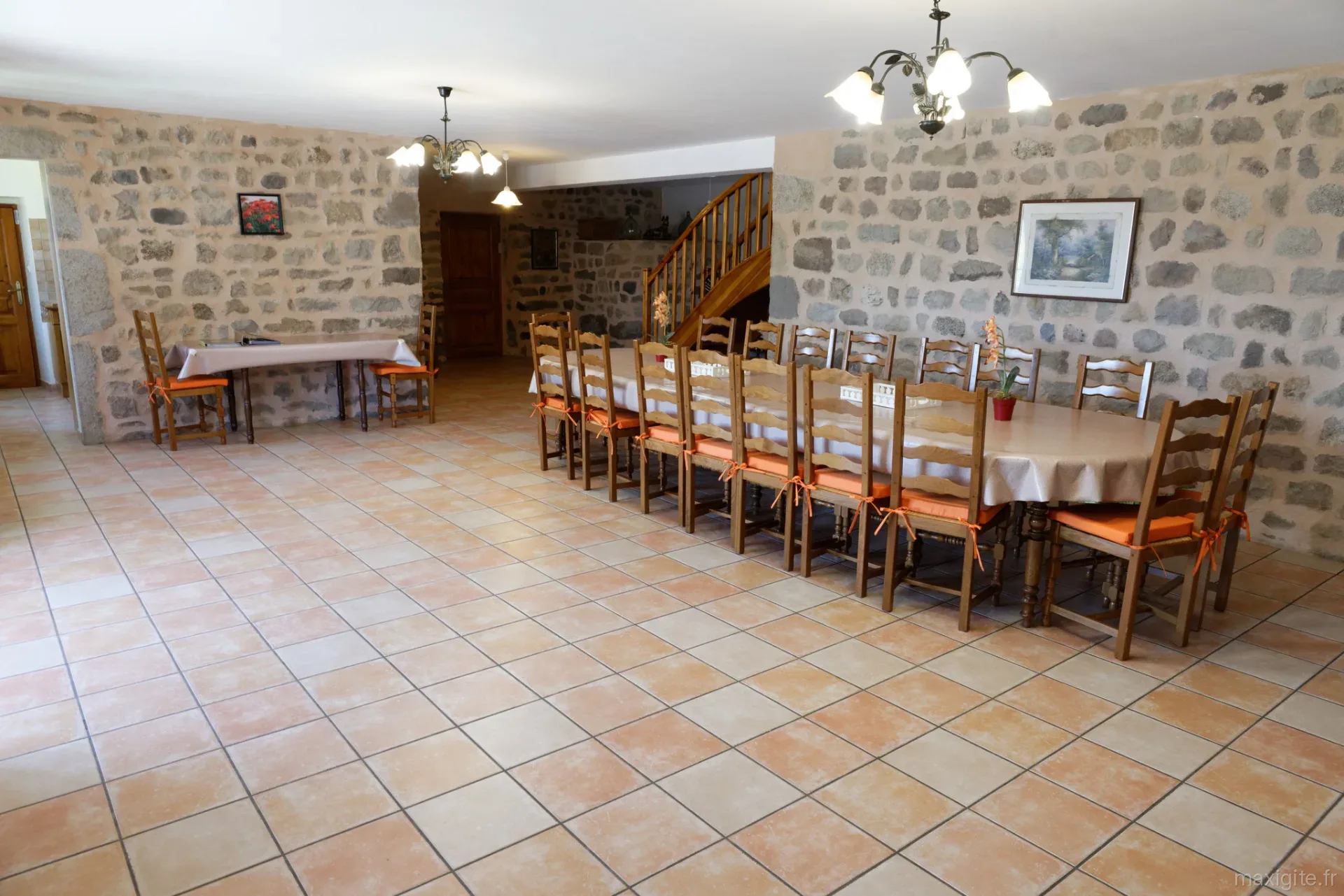 Grande salle à manger avec table en bois pouvant accueillir une quinzaine de convives