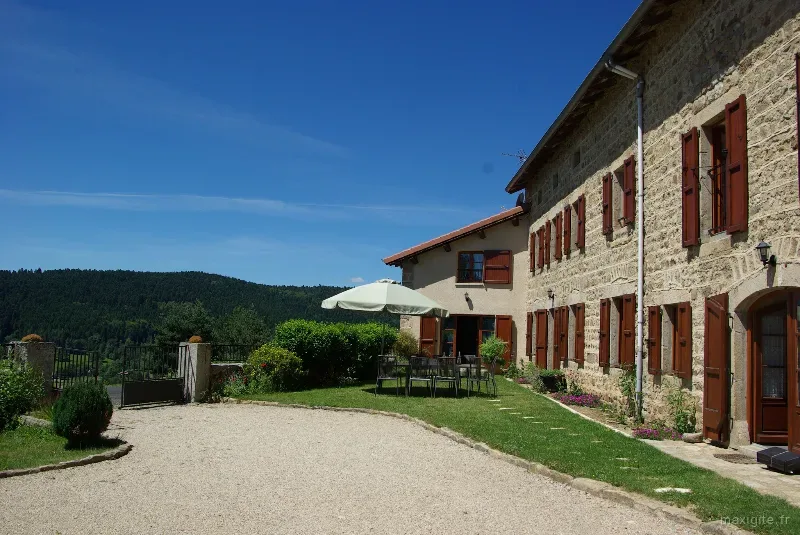 Façade et terrasse extérieure du gîte, murs en pierre typiques du plateau du Forez