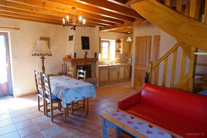 Cuisine avec coin repas et escalier en bois menant à l'étage