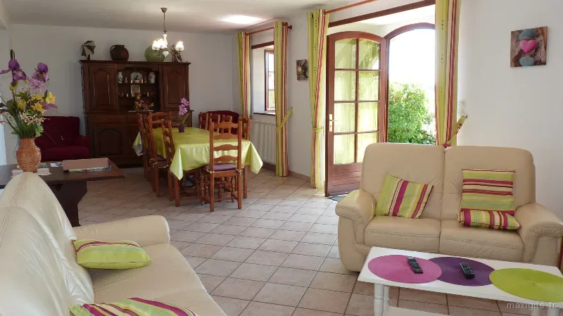 Séjour lumineux avec coin repas, vaisselier ancien et canapés donnant sur la terrasse