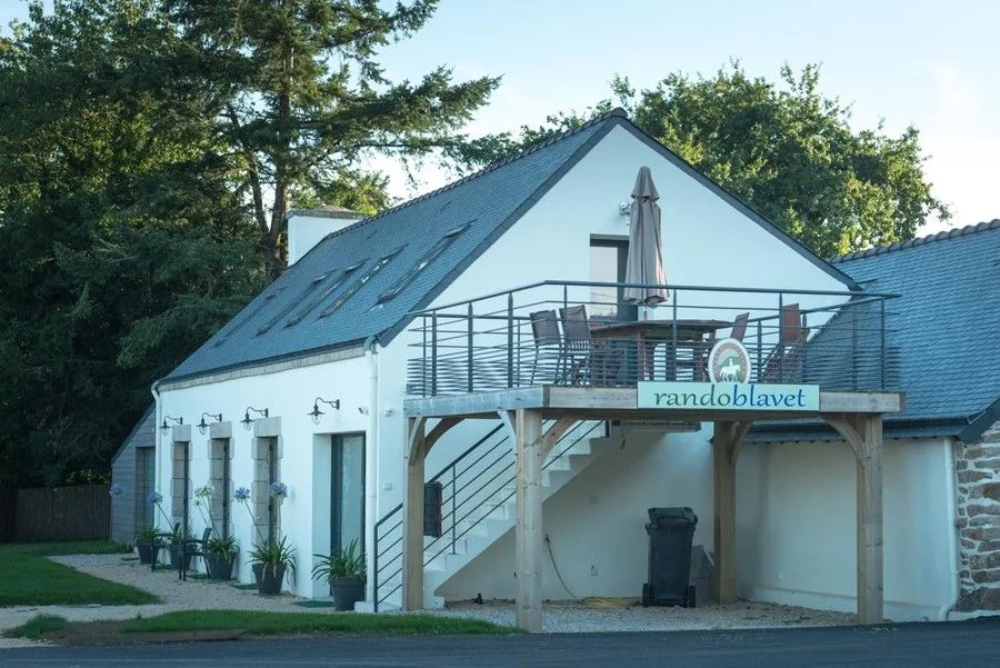Gîte de groupe Rando Blavet à Quistinic — Façade du gîte de ferme rénové avec terrasse en bois surélevée et escalier extérieur, capacité 15 personnes