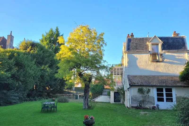 Vue arrière de la maison depuis le grand jardin arboré et engazonné