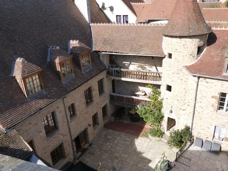 Cour pavée privée de L'Ancien Collège avec terrasse, salon de jardin et vue sur le mur du château