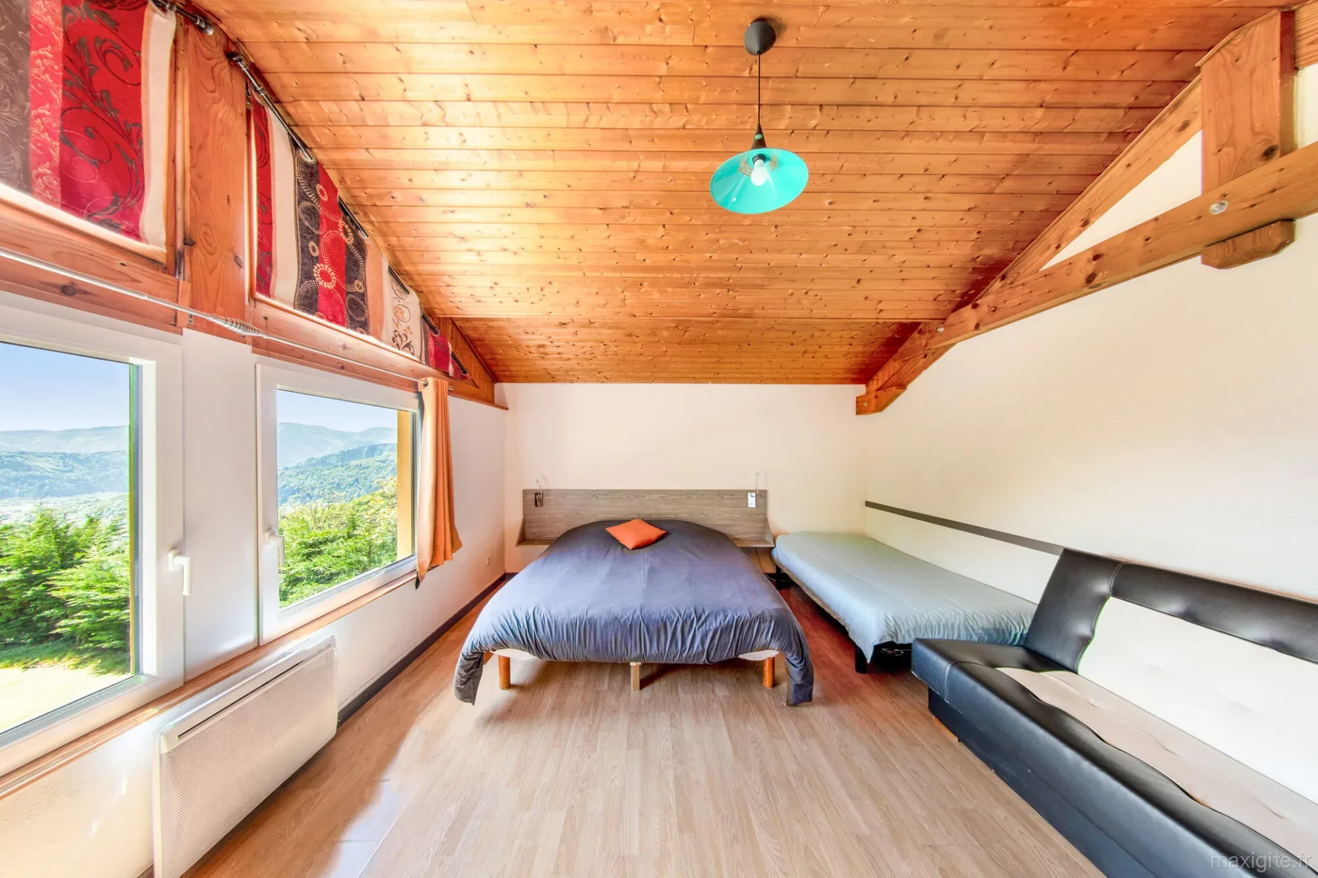 Chambre lumineuse avec lit double, lit simple et vue panoramique sur les montagnes