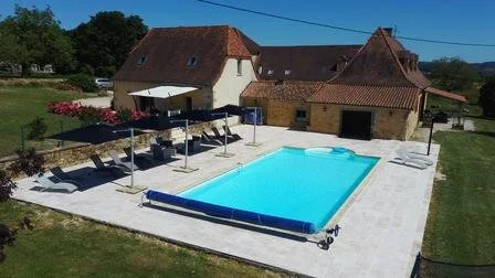 Vue aérienne du domaine avec piscine chauffée entourée de transats et terrasse en pierre