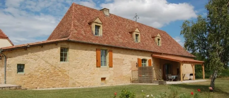 Façade du gîte La Girouette, ancienne bâtisse en pierre du 17e siècle sous toit en tuiles