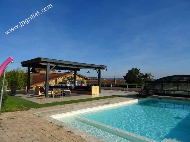 Piscine extérieure avec pergola lounge et vue sur les collines du Beaujolais des Pierres Dorées