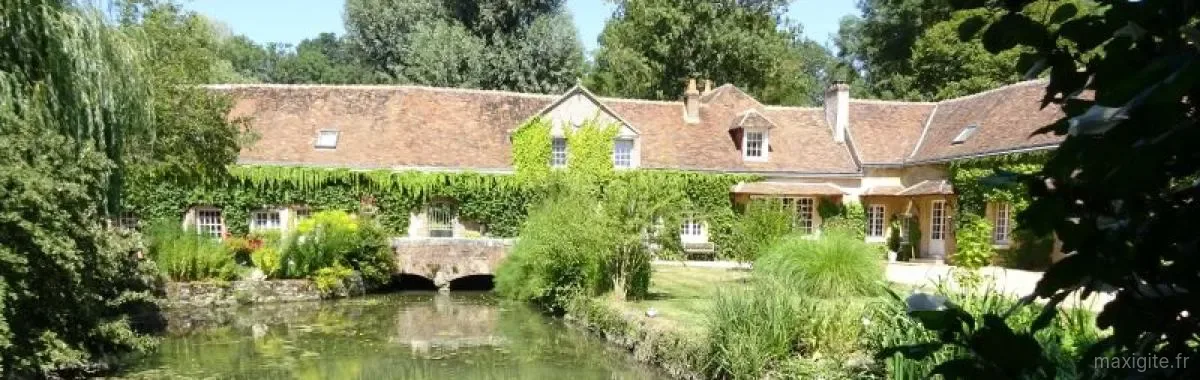 Gîte de groupe Le Moulin de Sainte Croix - Gîte de la Roue à Neuillé-le-Lierre — Longère couverte de vigne vierge reflétée dans l'étang du moulin, avec petit pont de pierre, capacité 15 personnes