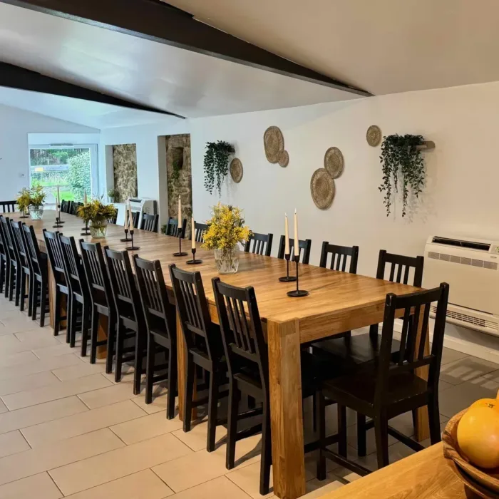 Grande salle à manger avec longue table en bois pour trente convives